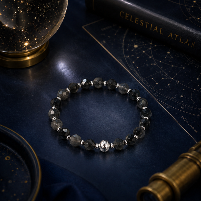Black beaded bracelet on a celestial-themed book with starry night sky background